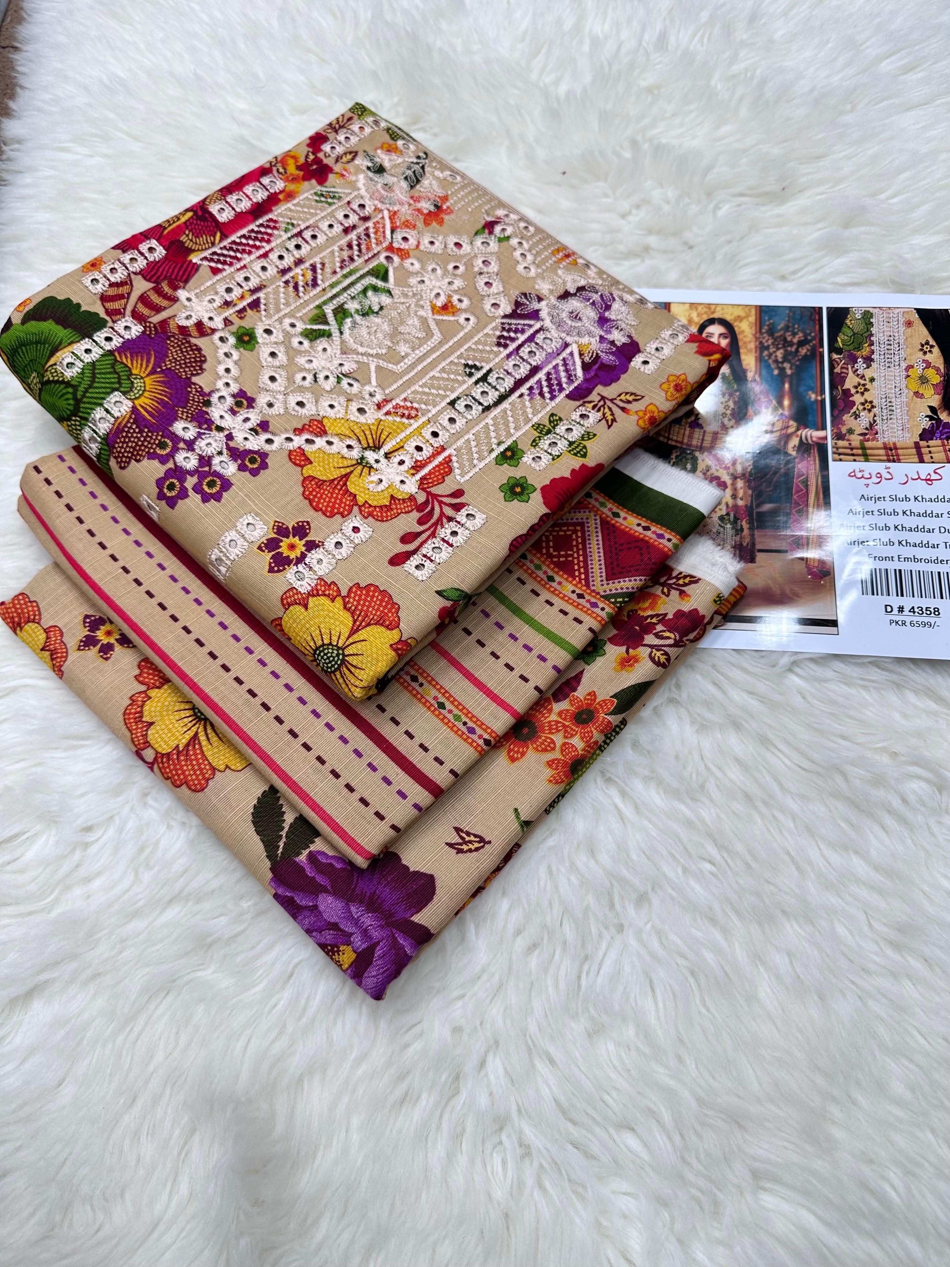 Stack of fabric samples with intricate patterns on a white surface