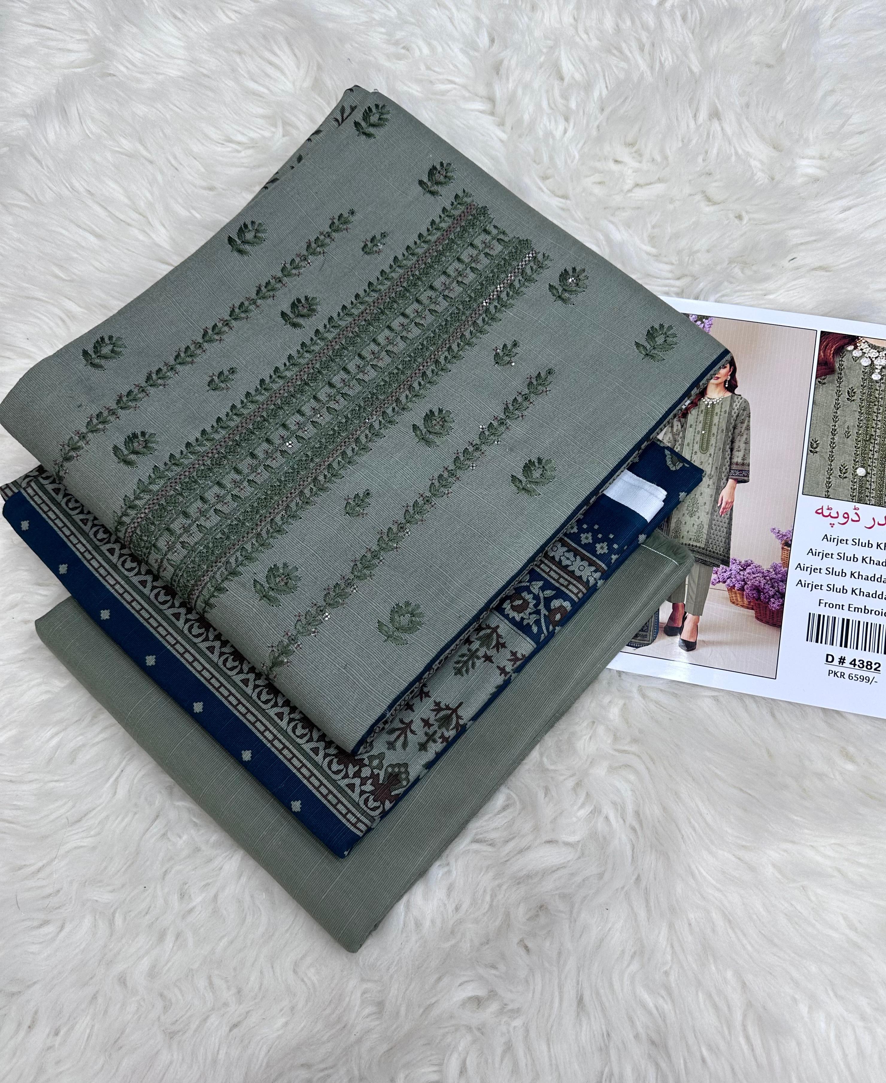 Gray fabric with green patterns on a white textured surface