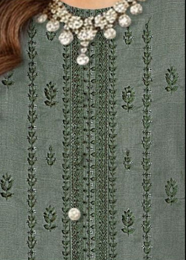 Woman wearing a green embroidered outfit with close-up details and product information.
