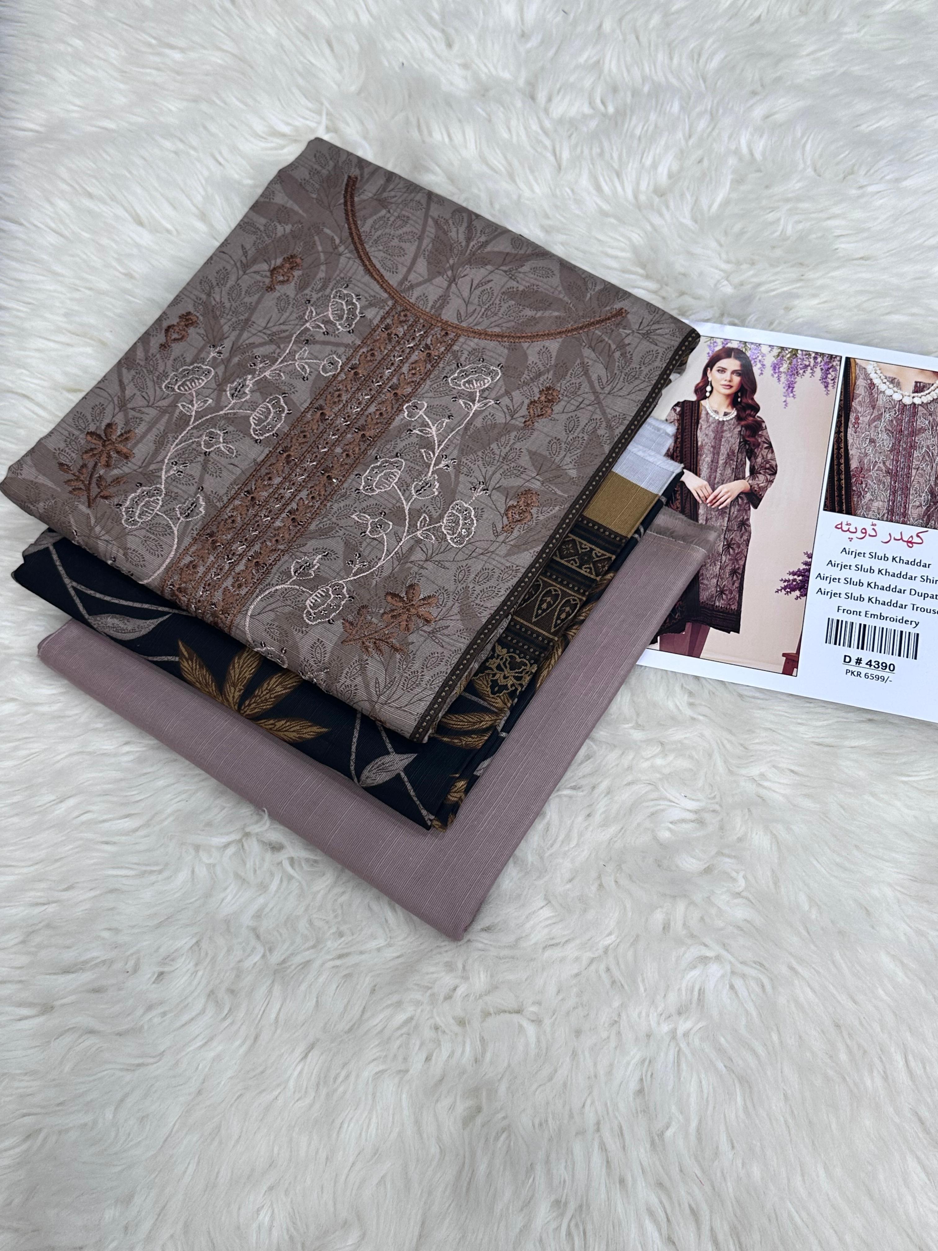 Stack of embroidered fabric pieces with a model picture on a textured surface